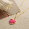 Minimalist gold chain necklace with a pink enamel heart pendant on beige texture - Pink