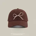 Dark brown UV protection baseball cap featuring a white embroidered minimalist bow design - Bowknot Embroidery Peaked Cap PY / Coffee