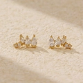 Elegant pair of gold studs featuring pear and round cut clear zircons on beige texture - 925 Silver / Gold Yellow