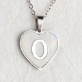 Silver heart shell necklace with letter O pendant on white textured fabric - Letter O / Silver