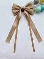 Dettaglio del fiocco per capelli in raso color champagne con lunghi nastri eleganti - Kaki