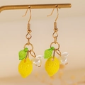 Detalle macro de pendientes de limón con hojas verdes y pétalos en soporte dorado - Estilo de Gancho de Oreja de Limón (0915)
