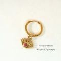 Macro view of gold hoop earring with evil eye pendant and red bead on fabric - Rhodochrosite Eye