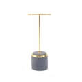 Macro detail of T-shaped jewelry display with grey velvet base and gold metal bar - Gray