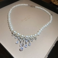 Macro shot of pearl necklace with zircon fringe in a gold jewelry display box - Silver Rhinestone Zircon Tassel Pearl Necklace