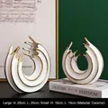 Set of two white ceramic wavy ring ornaments with gold trim in minimalist Nordic style - A Set Of Wave-shaped Vases (large And Small)