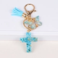 Dettaglio portachiavi a croce in resina con pietre blu, farfalla e nappa in azzurro - Blu (Y006-2)