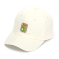 Detailed close-up of a cute green dinosaur rubber patch on a beige cotton kids baseball cap - 52-54cm / Off White