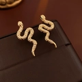 Macro shot of gold-plated snake earrings with white zircons and green gemstone eyes - Real Gold Plated Gold (Silver Needle)