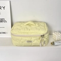 Close-up of light yellow cloud quilted cosmetic bag with heart pattern and ribbon zipper - Yellow