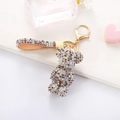 Close-up of sparkling rhinestone teddy bear keychain with brown leather strap detail - Mixed Coffee