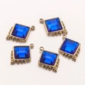 Dettaglio di cinque ciondoli quadrati in vetro blu con perline dorate per bigiotteria - Quadrato / Blu A (13mm)