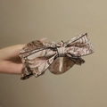 Rosa Schleife Haarklammer mit schwarzem Blumenmuster und elegantem Bananen-Clip-Design - Kaffeemuster