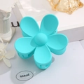 Detail view of macaron blue flower hair claw clip with matte texture and five-petal design - Cyan