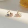 Detailed view of ocean-style asymmetric earrings featuring starfish and pink shell charm - Pink