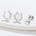 Detailed macro shot of silver horseshoe earrings with textured holes and butterfly backs - Steel