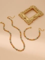 Dettaglio del set di gioielli con foglie smaltate e collana e bracciale dorati - Set Multicolore