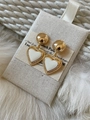 Macro dettaglio di orecchini vintage a cuore in oro 18K e smalto bianco su tessuto - E1826 Smalto crema / Cuore in smalto bianco crema