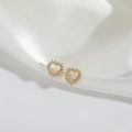 Elegant gold heart stud earrings with white zircon accents on white silk background - Heart