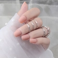 Dettaglio di set anelli argento con unghie finte rosa opaco su pizzo bianco - Unghia Quadrata Corta (DFM-12) / Con colla / Rosa nude opaco