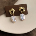 Detailed macro shot of baroque irregular pearl earrings with golden liquid metal accents - Style 30
