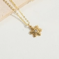 Collana con ciondolo a fiocco di neve dorato e gemma su sfondo di pietra naturale - Fiocco di neve