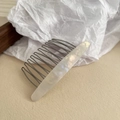 Detailed close-up of acetate side comb with white marble texture and metal teeth - Mermaid White