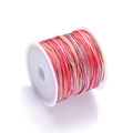 Macro view of gradient colorful braided jewelry cord wound on a white spool - Color No. 12