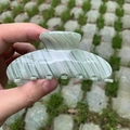 Large hair claw clip in green and white marble pattern shown in a handheld outdoor view - Green Stripes