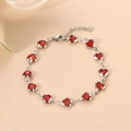 Charming silver chain bracelet featuring thirteen vibrant red heart-shaped crystals - Red