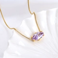 Golden necklace with a purple marquise-cut zircon pendant on a decorative shell - Capricorn