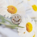 Golden round smiley face brooch with clear crystals on white daisy background - X017 Gold Rhinestone Smiley Brooch