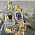 Close-up of golden oval luxury watch with blue dial and diamond-set bracelet next to perfume - Gold Blue Face