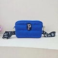 Detailed macro view of the blue quilted crossbody bag featuring a golden 'P' patch detail - Dark Blue