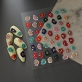 Stickers ongles 5D embossés avec lettres dorées et accents cristaux sur ongles blancs - Style Lettre Relief Style Sceau de Cire (CO-190)