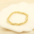 Macro view of textured and polished gold beaded stretch bracelet on white shell dish - BR1683-G/Gold Frosted & Mirror Beads