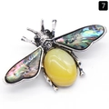 Bee brooch with silver wings, abalone shell inlay, and yellow oval gemstone on white background - Agate