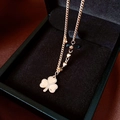 Détail du pendentif trèfle en or rose avec gravure 520 sur plateau en velours noir - Style Gravé 520 / Doré