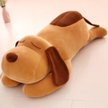 Brown plush dog pillow in lying position with soft fur on a wooden background - 32cm / Brown
