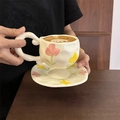 Detailed close-up of hand-painted tulip patterns on a cream ceramic coffee cup and saucer - Pink Tulip Cup & Saucer Set / Cup + Saucer Set