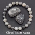 Macro detail of natural grey Cloud Water Agate beaded bracelet and polished raw stones - Grey Agate