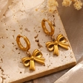 Elegant gold bow earrings displayed on stone with silk fabric and dried flowers detail - Bowknot Earrings (6939)