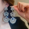 Dettaglio di orecchini a fiori in argento con cristalli scintillanti a goccia su modella - 5-Perno in Argento-Argento-Lampadario Traforato Multistrato