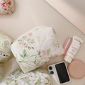 Trousse de maquillage matelassée à fleurs roses présentée en vue de dessus sur un bureau - Grand Motif Floral Rose