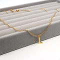 Close-up of golden letter L pendant necklace on gray velvet jewelry display tray - L / Gold