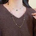 Detail view of a layered golden beaded necklace set worn over a brown knit sweater - Gold Double Square Beads (46#)