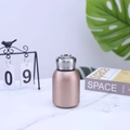 Detail of rose gold mini vacuum flask with foldable metal handle on marble surface - 300ml / Gold