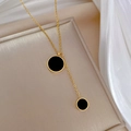 Detalle del collar de acero al titanio dorado con dos colgantes redondos negros en bandeja - Dorado (N222)