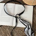 Vintage black leather belt featuring a black and white paisley silk scarf detail - Black