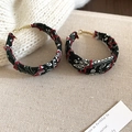 Detailed close-up of bandana print hoop earrings with hand-stitched red thread accents - Green